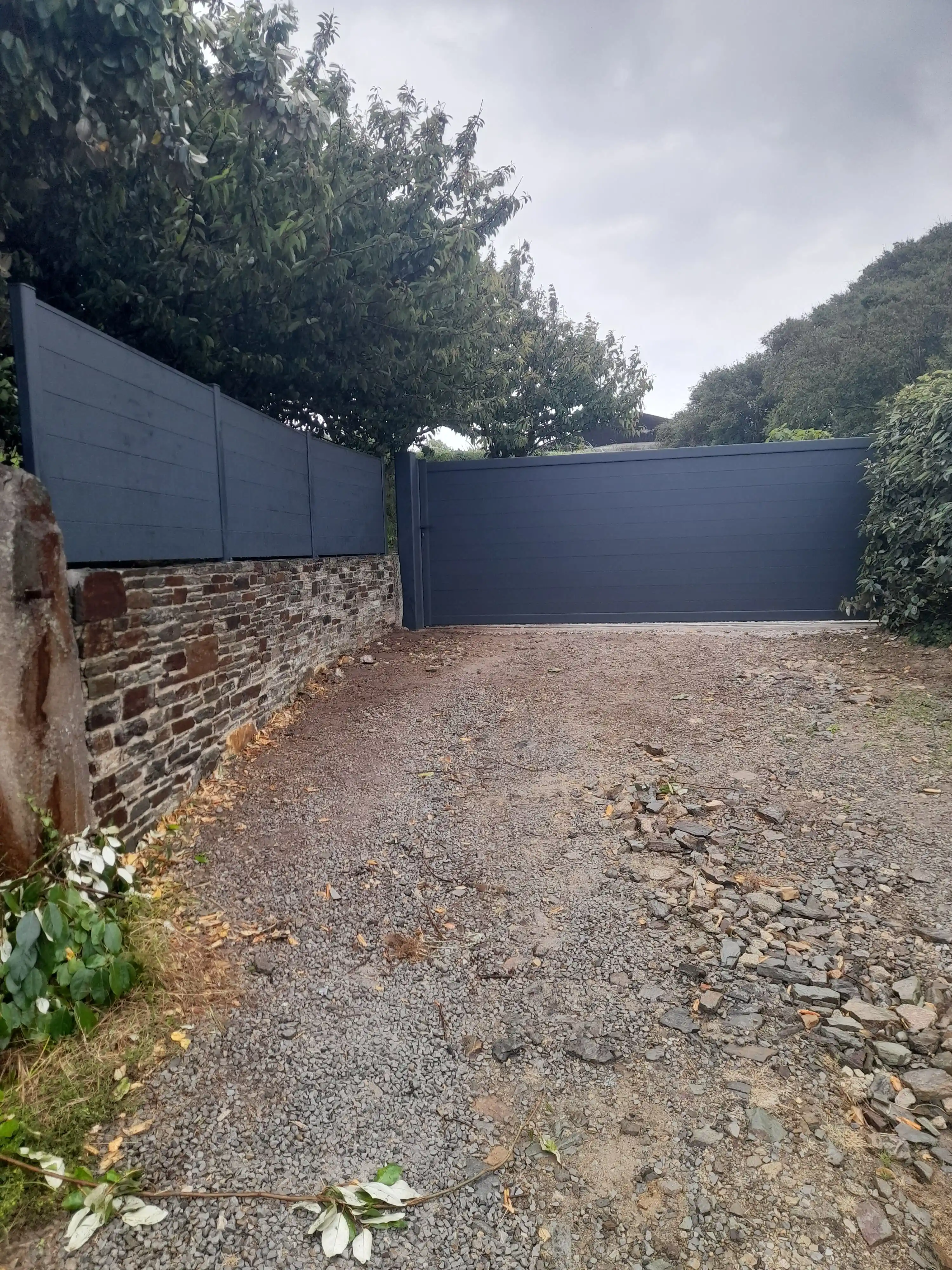 Installation de portail coulissant contemporain avec clôture assortie