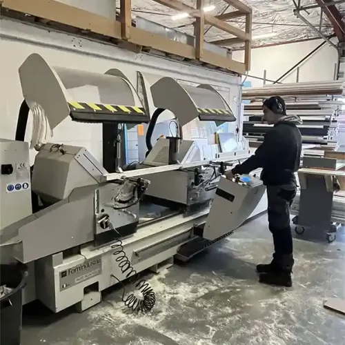 Scie double tête utilisée dans un atelier de fabrication de menuiseries aluminium