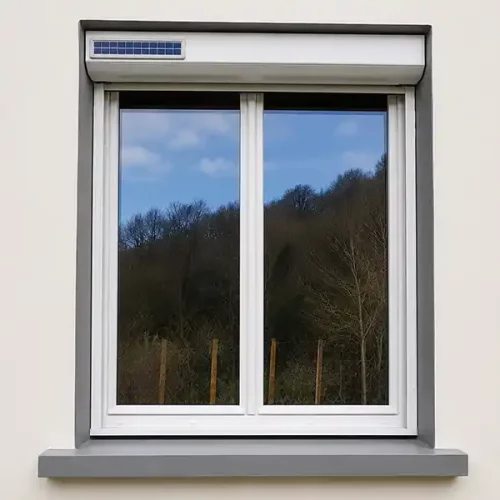 Fenêtre PVC blanche avec volet roulant solaire motorisé installé par Performances Menuiseries