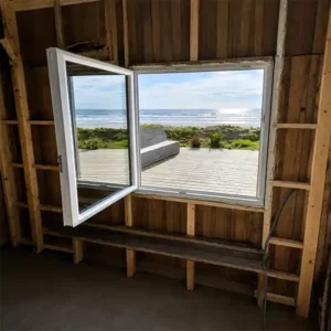 Installation de fenêtre moderne dans maison en bord de mer avec vue océan