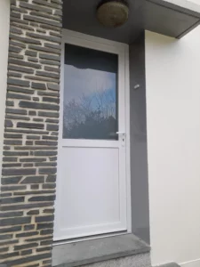 Porte d’entrée PVC blanche vitrée moderne installée en rénovation extérieure