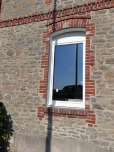 Rénovation de fenêtre blanche moderne sur maison ancienne en pierre