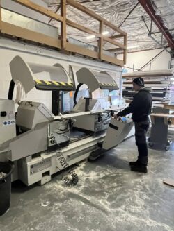 Un compagnon procède à la découpe de profilés-performances menuiseries Un compagnon procède à la découpe de profilés