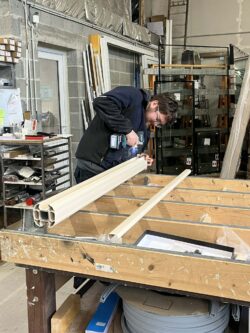 Un compagnon en train d'ajuster une menuiserie-performances menuiseries Un compagnon en train d'ajuster une menuiserie