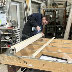 Travail de précision pour l’assemblage de menuiseries sur mesure Assemblage de menuiserie PVC sur table de travail en atelier