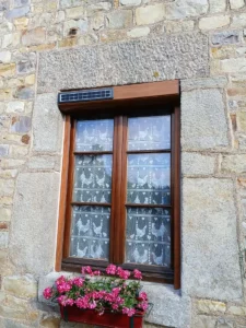 Fenêtre PVC avec volet roulant solaire chêne doré installée sur une maison dans le Cotentin