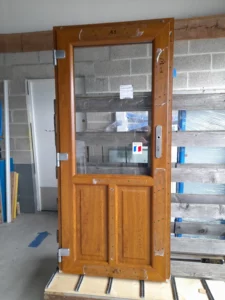 Fabrication de porte d’entrée bois avec vitrage supérieur et panneaux décoratifs