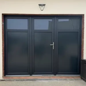 Vue extérieure d'une porte de garage 3 vantaux en PVC installée par Performances Menuiseries